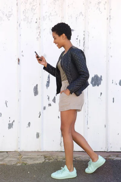 Женщина ходит с мобильным телефоном — стоковое фото