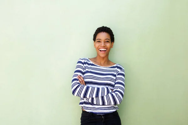 Женщина улыбается на фоне зеленой стены — стоковое фото