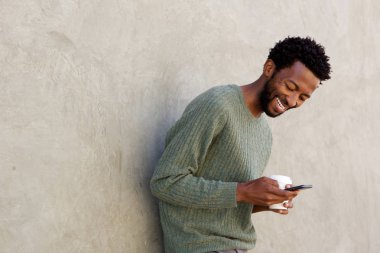 adam holding kahve ve telefon