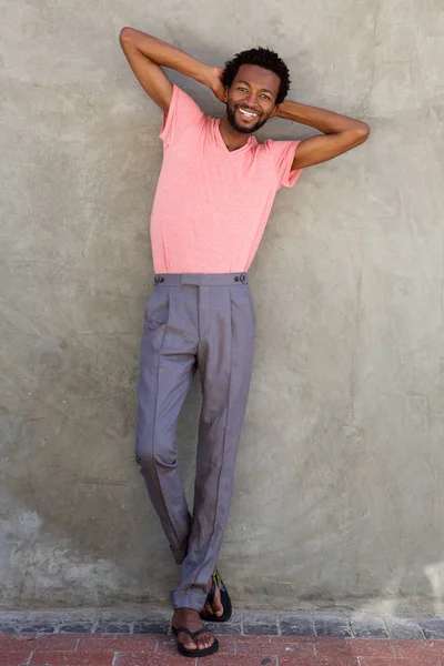 Hombre sonriendo con las manos detrás de la cabeza —  Fotos de Stock