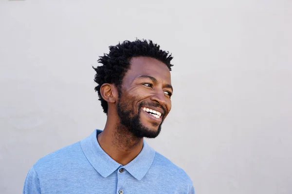 Hombre sonriendo por la pared blanca —  Fotos de Stock