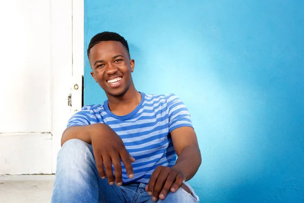 Man sitting by blue wall — Stock Photo, Image