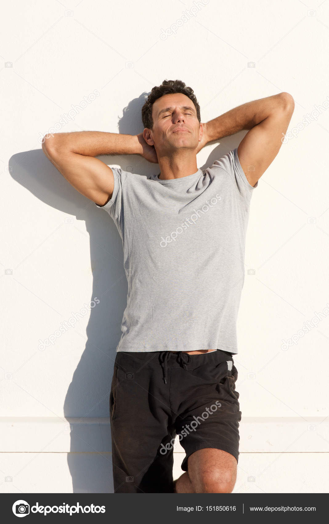 白い壁にもたれて男 ストック写真 C Mimagephotos