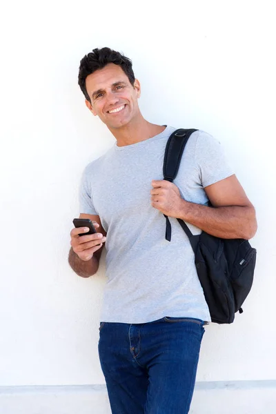 Pohledný muž s vakem a mobil — Stock fotografie