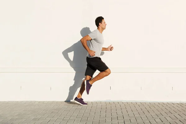 Hombre corriendo por la pared blanca — Foto de Stock