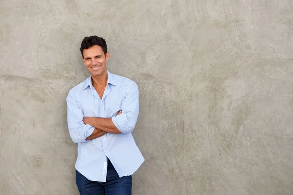 Handsome man standing by wall — Stock Photo, Image