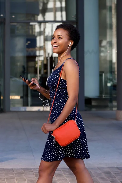 Kvinnan promenader utanför med telefon — Stockfoto
