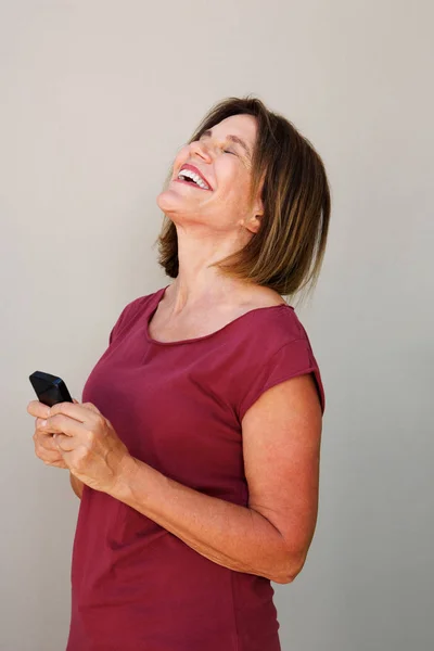 Жінка сміється з мобільного телефону — стокове фото
