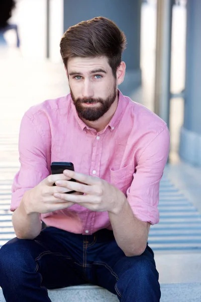 Homem sério segurando telefone — Fotografia de Stock