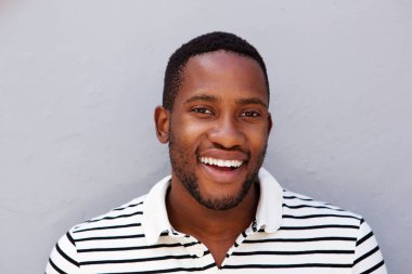 gri duvara gülümseyen adam