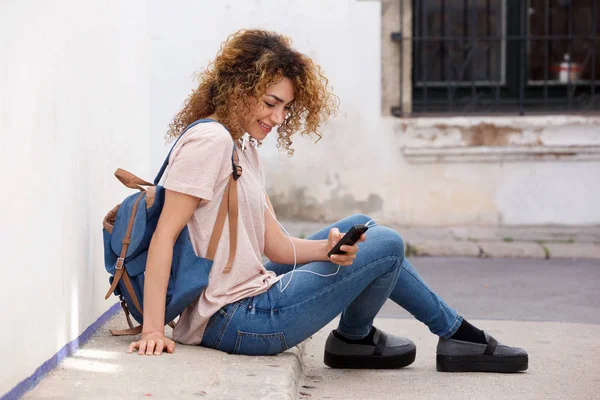 Молодая женщина, сидящая на улице — стоковое фото