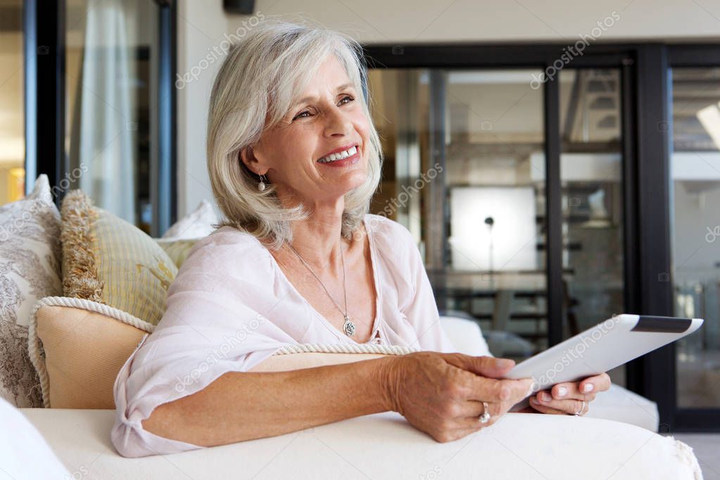 happy older woman sitting on sofa 