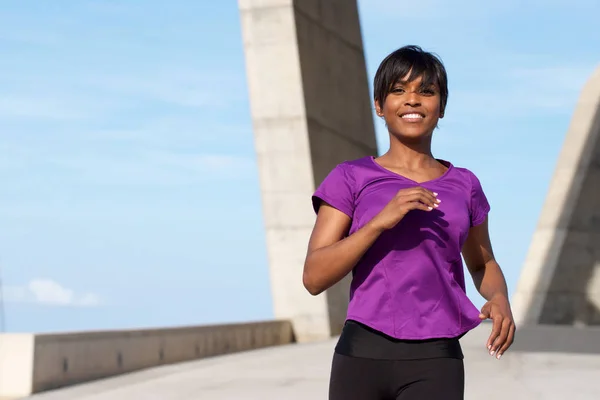 Junge Frau joggt draußen — Stockfoto