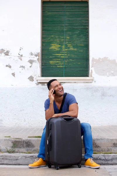 african man sitting with suitcase