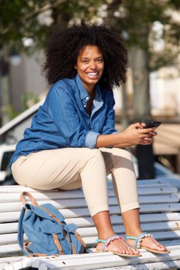 Gülümseyen bankta oturan kadın  