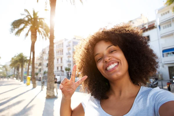 Vrouw maakt vredesteken — Stockfoto