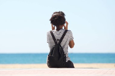 Deniz kenarında oturan öğrenci 