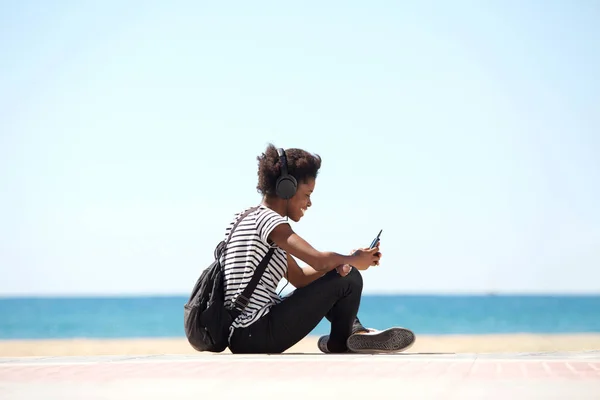 Chica sentada junto a la playa — Foto de Stock