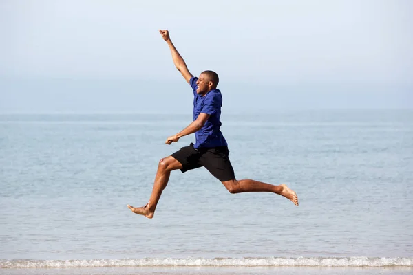 Guy running and jumping along sea — Stock Photo, Image