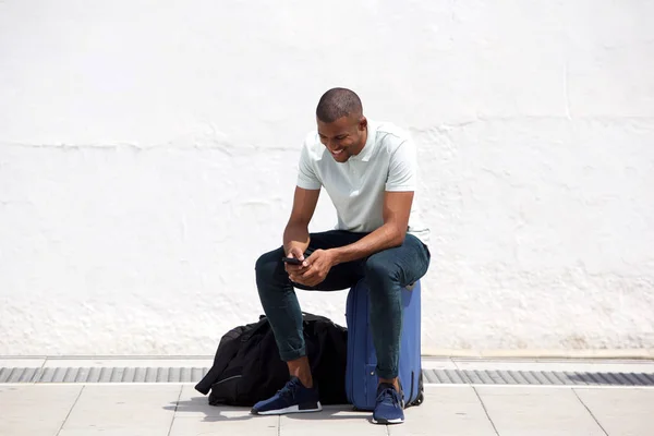 Man sitting on suitcase — Stock Photo, Image