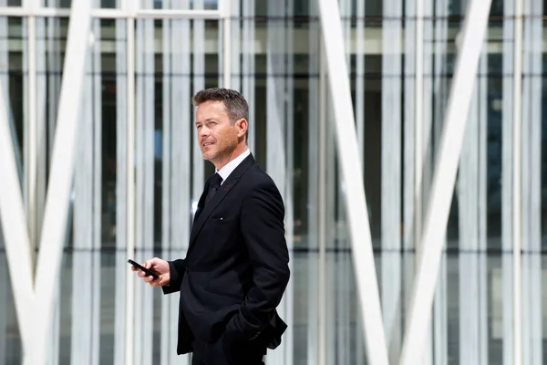 Zakenman denken en houden van de telefoon — Stockfoto