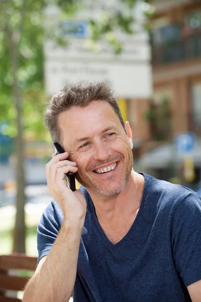 Laughing man sitting on bench — Stock Photo, Image