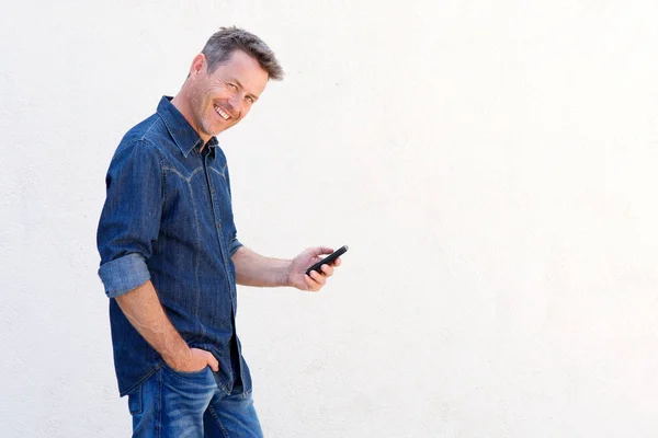 Hombre sonriendo y sosteniendo el teléfono — Foto de Stock