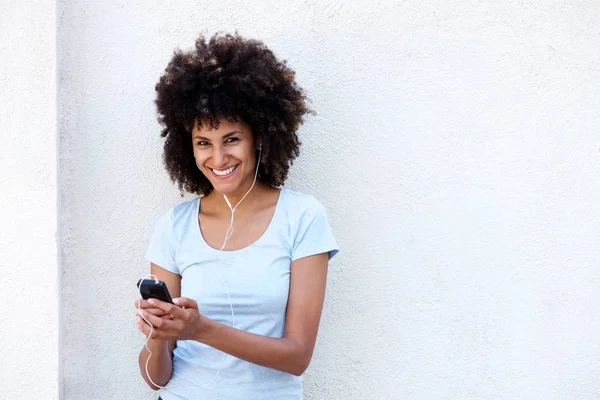 Vrouw houden van mobiele telefoon en luisteren naar muziek — Stockfoto