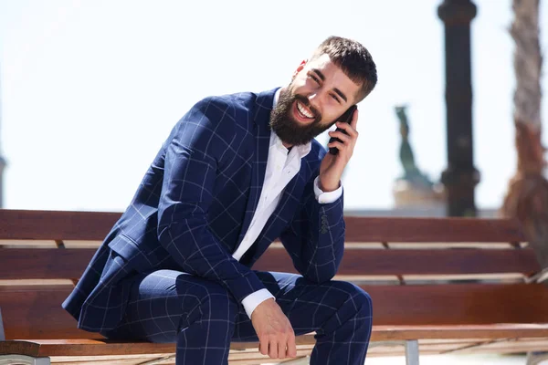 Happy businessman sitting on bench — Stock Photo, Image