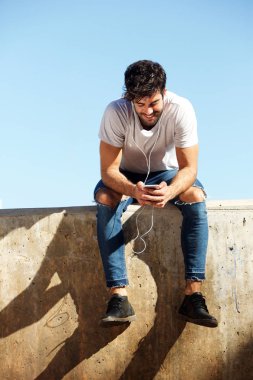 Beton duvara oturan adam 