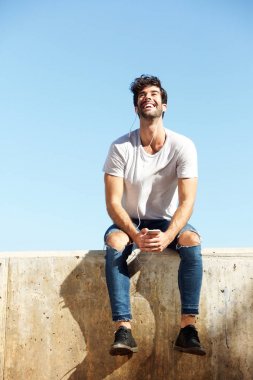 Beton duvara oturan adam 