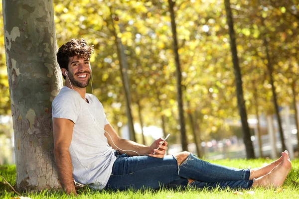 Gelukkig man zit in gras — Stockfoto