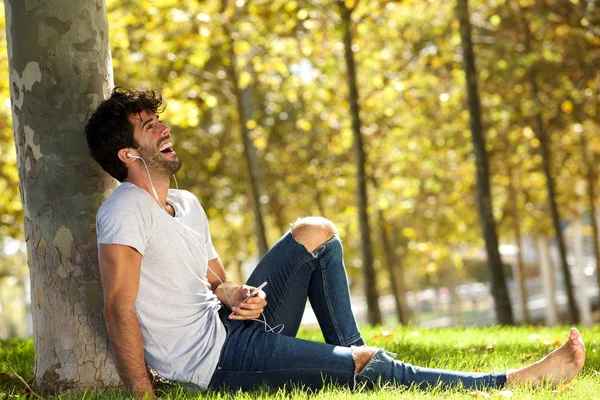 Homme riant assis dans l'herbe — Photo