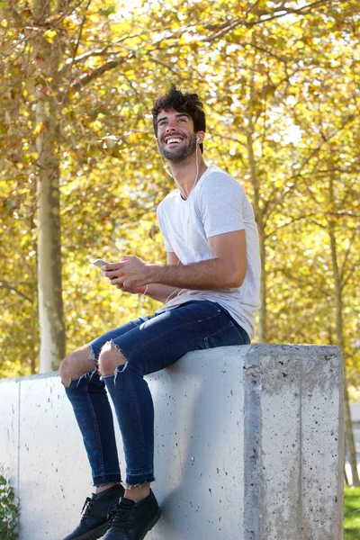 Człowiek śmiechu siedzi przez drzewa — Zdjęcie stockowe