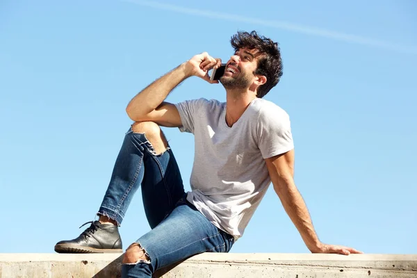 Mann sitzt auf Betonmauer — Stockfoto