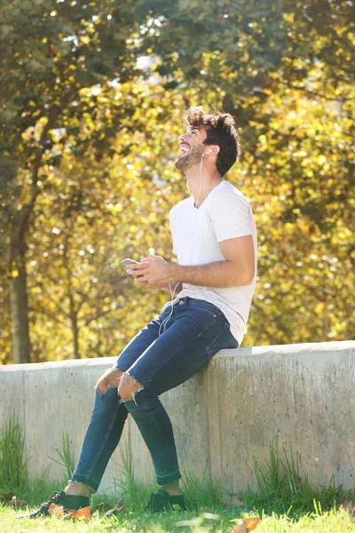 Fröhlicher Mann sitzt auf Mauer — Stockfoto