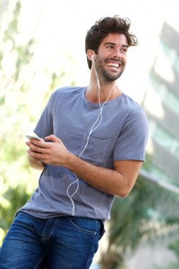 Gülümseyen adam şehirde duruyor. 