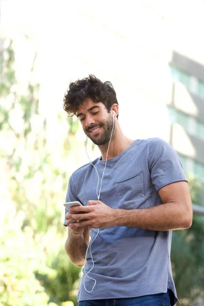 Usmívající se muž, který stojí se sluchátky — Stock fotografie