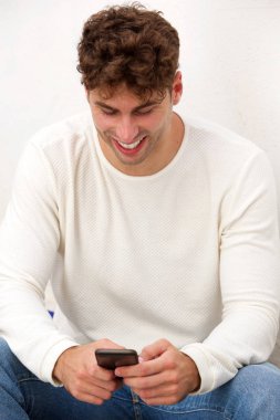 Telefon ile oturan adam gülüyor 