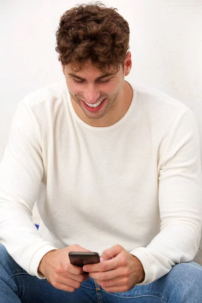 Telefon ile oturan adam gülüyor 