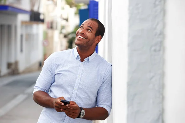 携帯電話で通りに外に立って幸せな男の肖像 — ストック写真