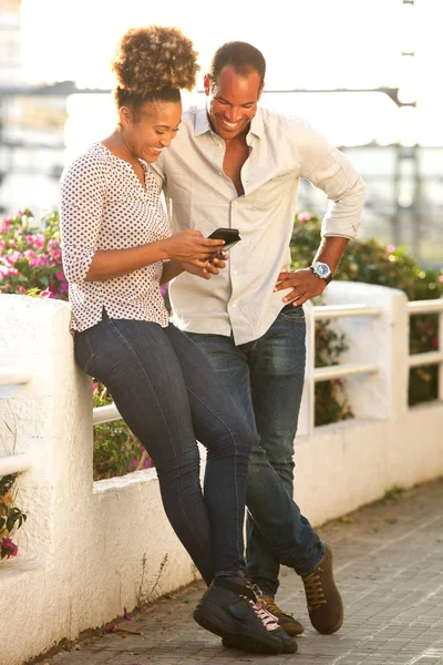 Full Längd Porträtt Lyckliga Par Stående Utanför Tittar Mobiltelefon — Stockfoto