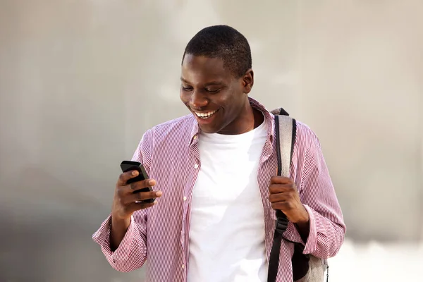 バッグの外に立って 携帯電話でテキスト メッセージを読んでアフリカ学生の肖像画 — ストック写真
