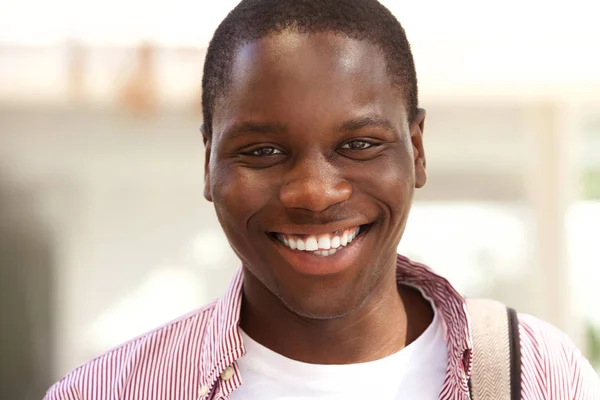 Close up portrait of happy black college student smiling outside