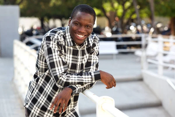 Πορτρέτο Του Χαρούμενος Νεαρός Άνδρας Που Γέρνει Ένα Κιγκλίδωμα Έξω — Φωτογραφία Αρχείου
