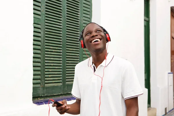Porträtt Leende Ung Man Lyssnar Musik Med Mobiltelefon Och Hörlurar — Stockfoto