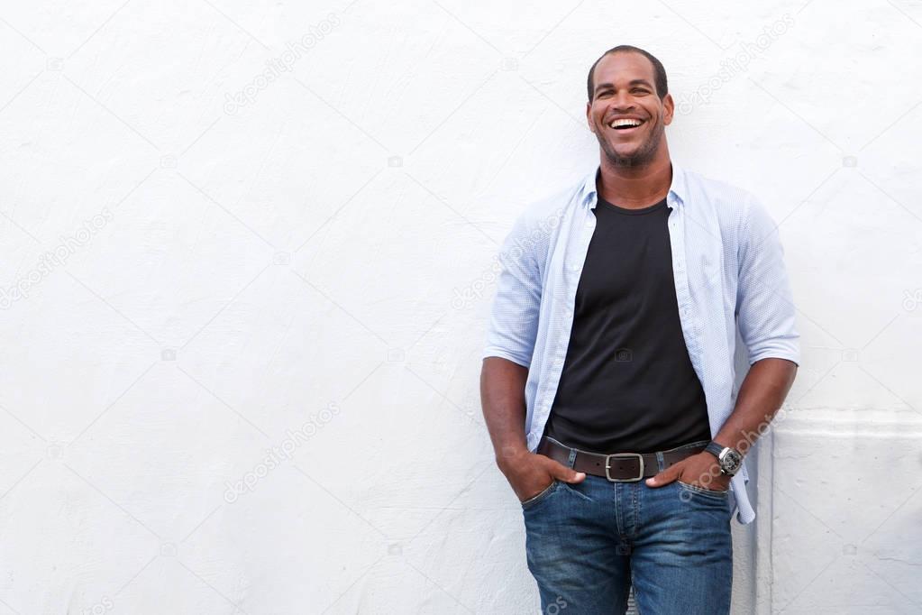 Portrait of attractive man standing and laughing on white background