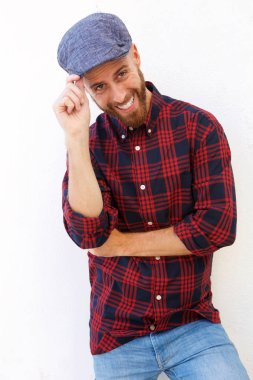 Şapkalı beyaz arka planı gülümseyen yakışıklı genç adam portresi