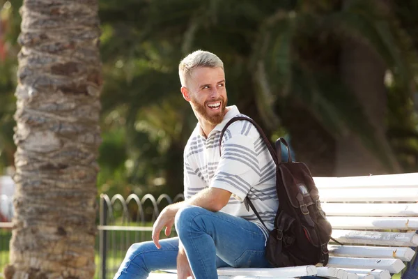 Portret Uśmiechający Się Młodego Człowieka Brodą Siedział Zewnątrz Parku — Zdjęcie stockowe