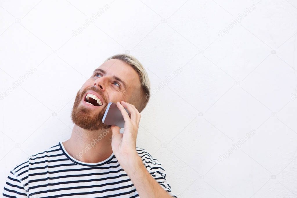 Close up portrait of happy young man talking on cell phone against white background 